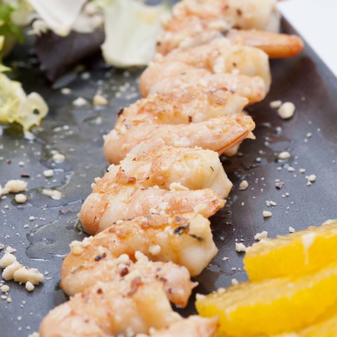 Brocheta de langostinos y coco con vinagreta de naranja