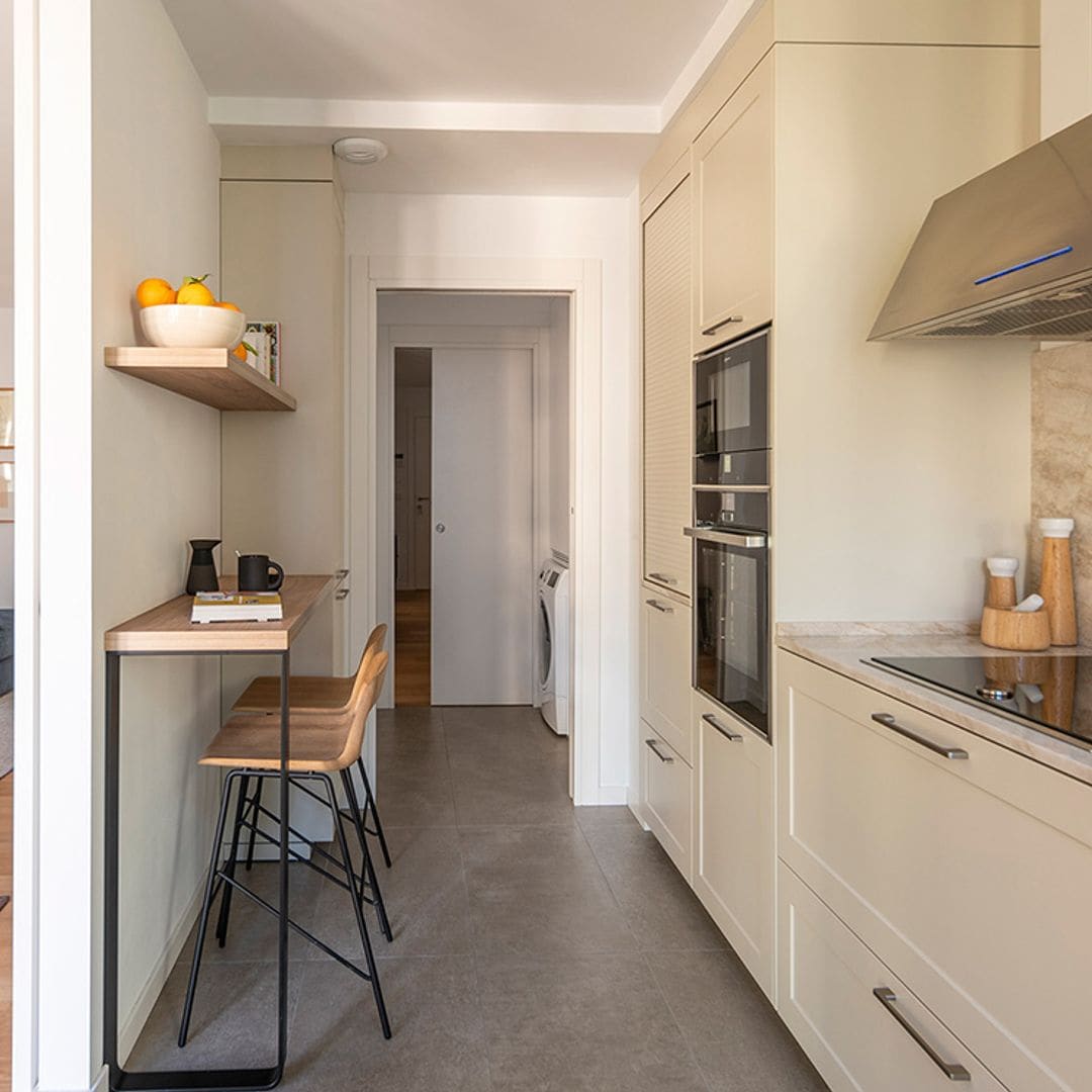 Una cocina alargada con cuarto de lavado y 'minioffice'