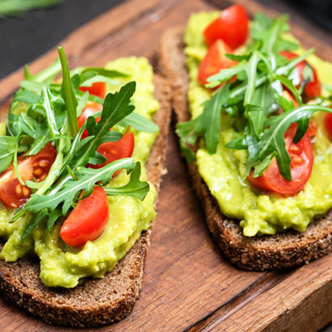 Tostadas integrales de aguacate, tomates y rúcula