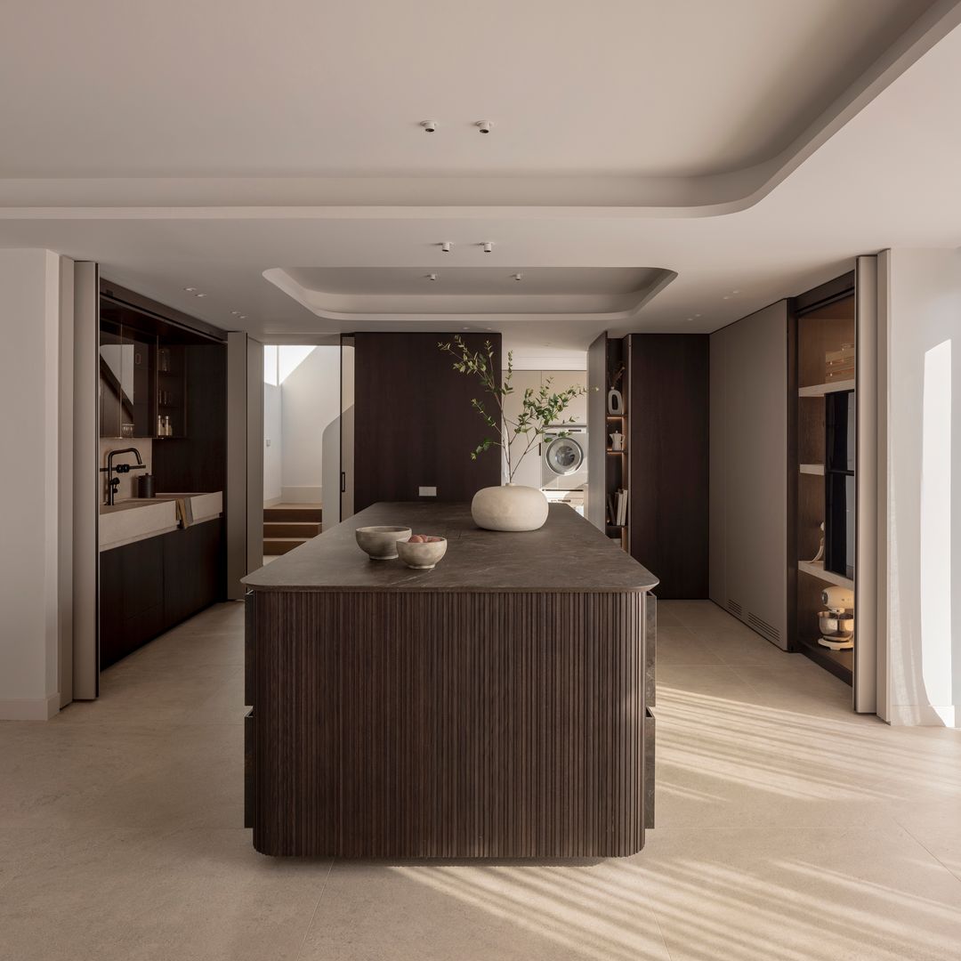 Isla curva, madera oscura y puertas ocultas: así es la cocina que marca la tendencia del año