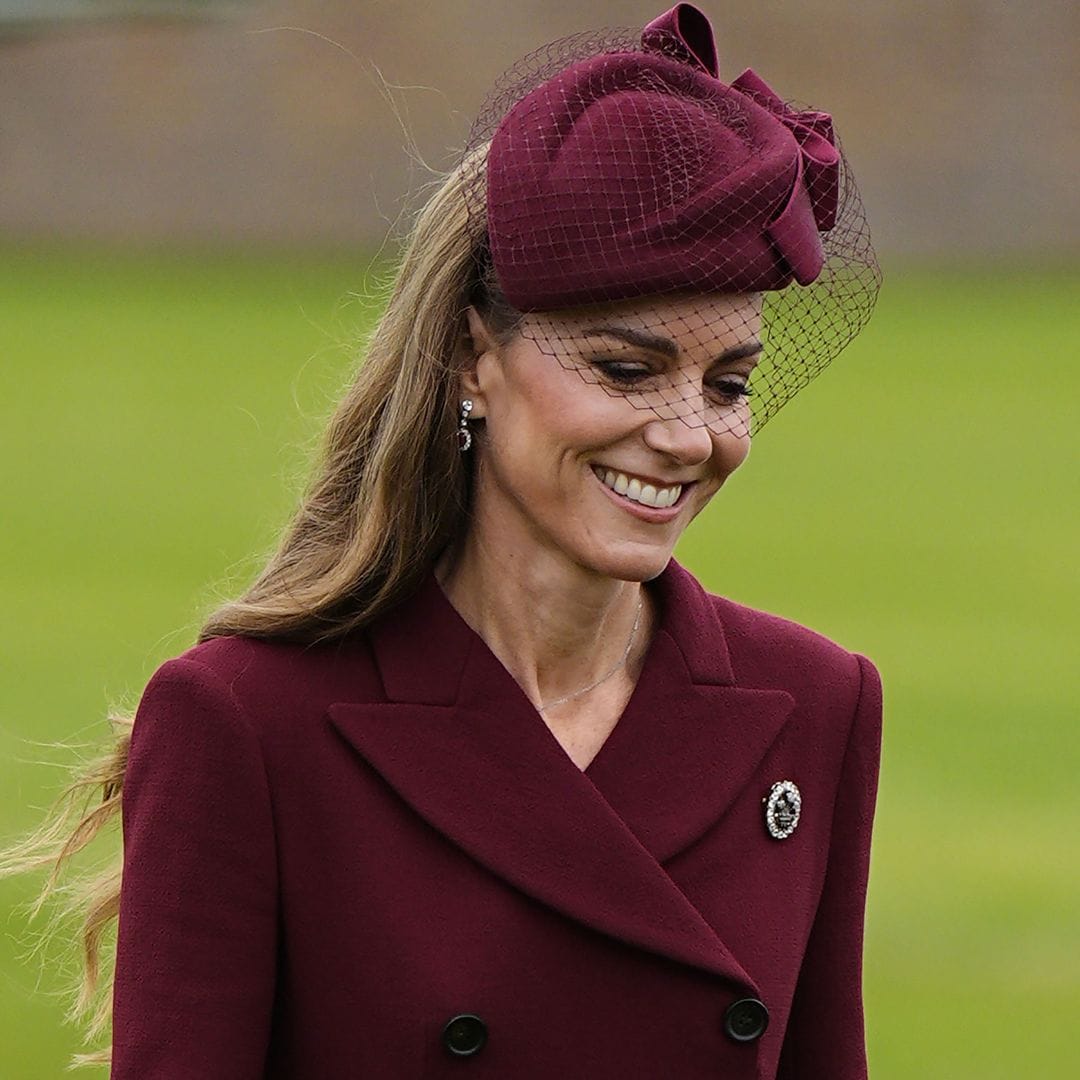 Kate Middleton con vestido cruzado granate y tocado con velo