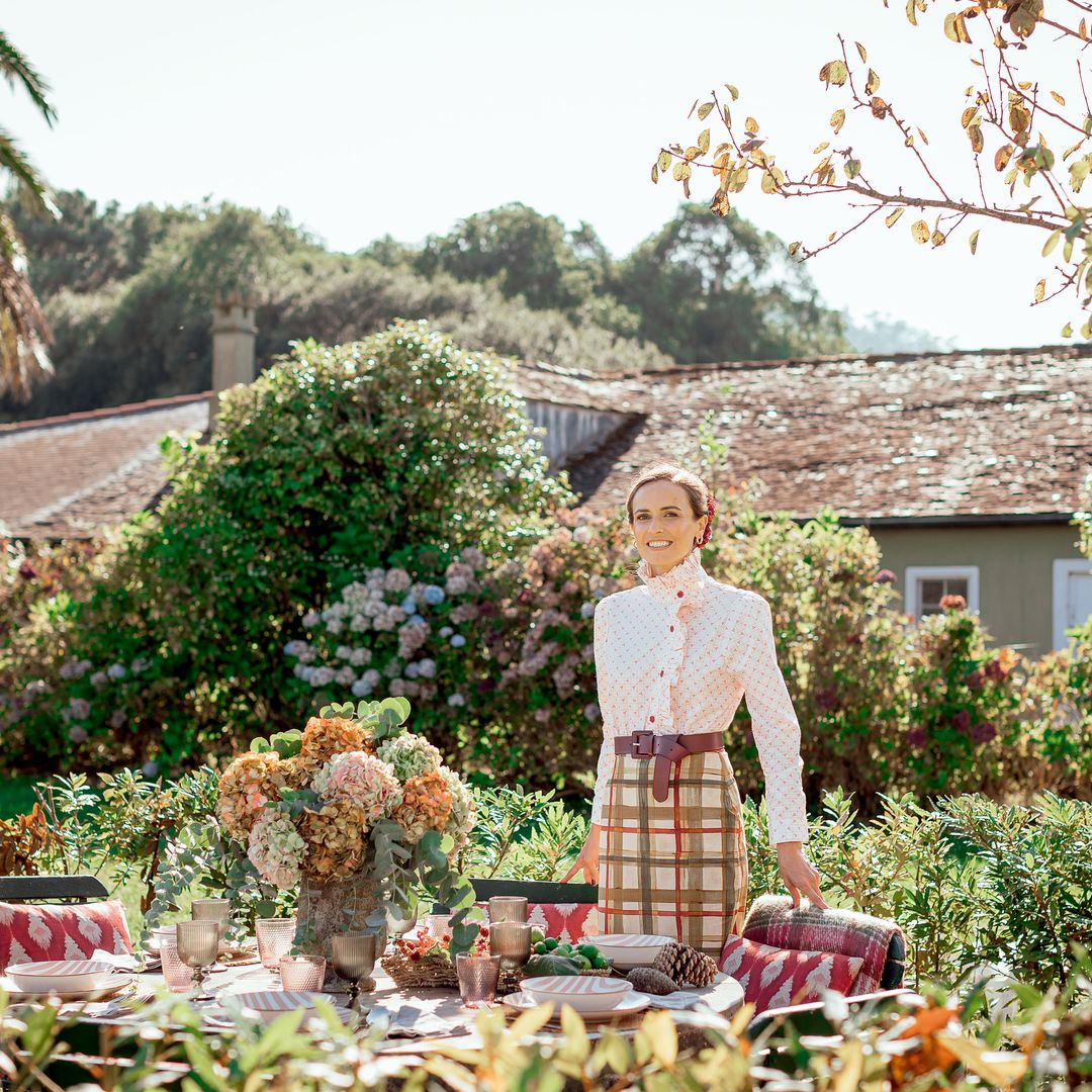 A la mesa: El comedor exterior de la casa, mirando al sur y protegido del famoso ‘nordés’ de la zona, es perfecto para los primeros días de otoño. Sobre la mesa, menaje y cojines de Casa Viva, flores de Colmenero Atelier y frutos de otoño de la propia finca