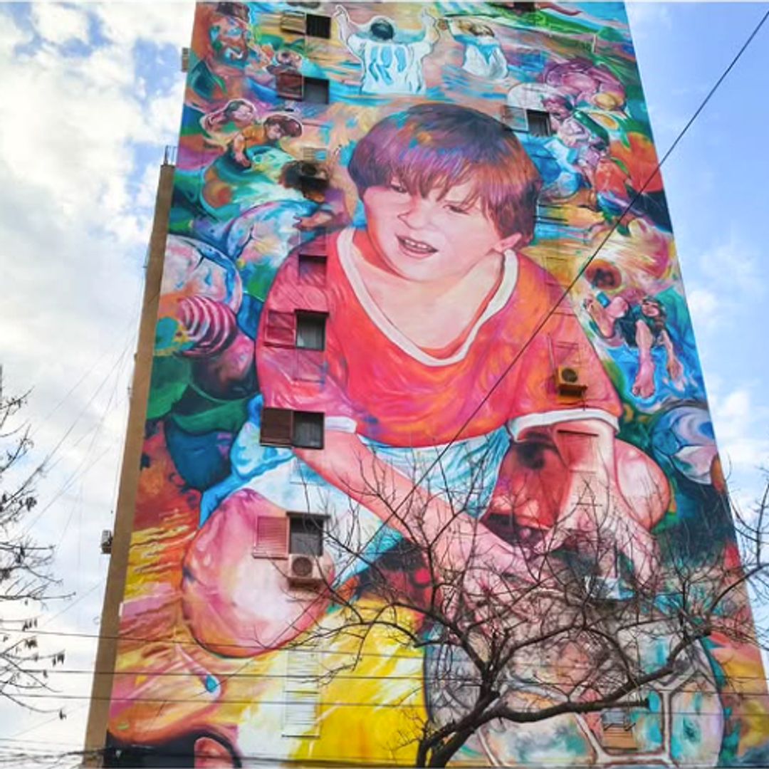 'De otra galaxia y de Grandoi' es el título de este mural que retrata a Messi de niño con la camiseta roja del club donde dio sus primeros pasos con el fútbol.