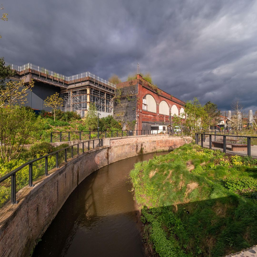 El río Medlock fluye a través de Mayfield Park y Depot Mayfield a la izquierda, Manchester