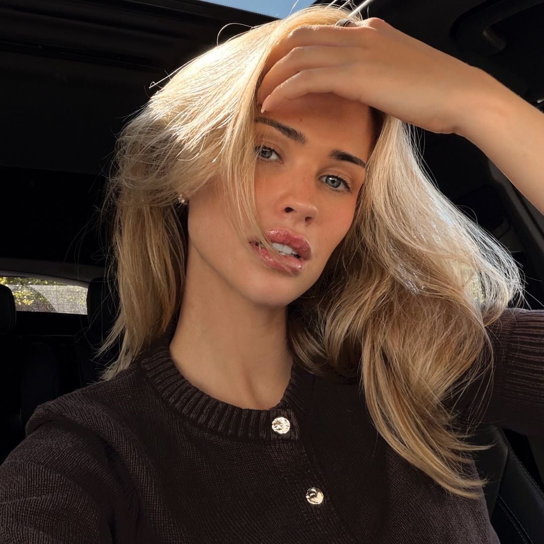 Selfie de chica rubia en el coche con jerset marrón de botones dorados