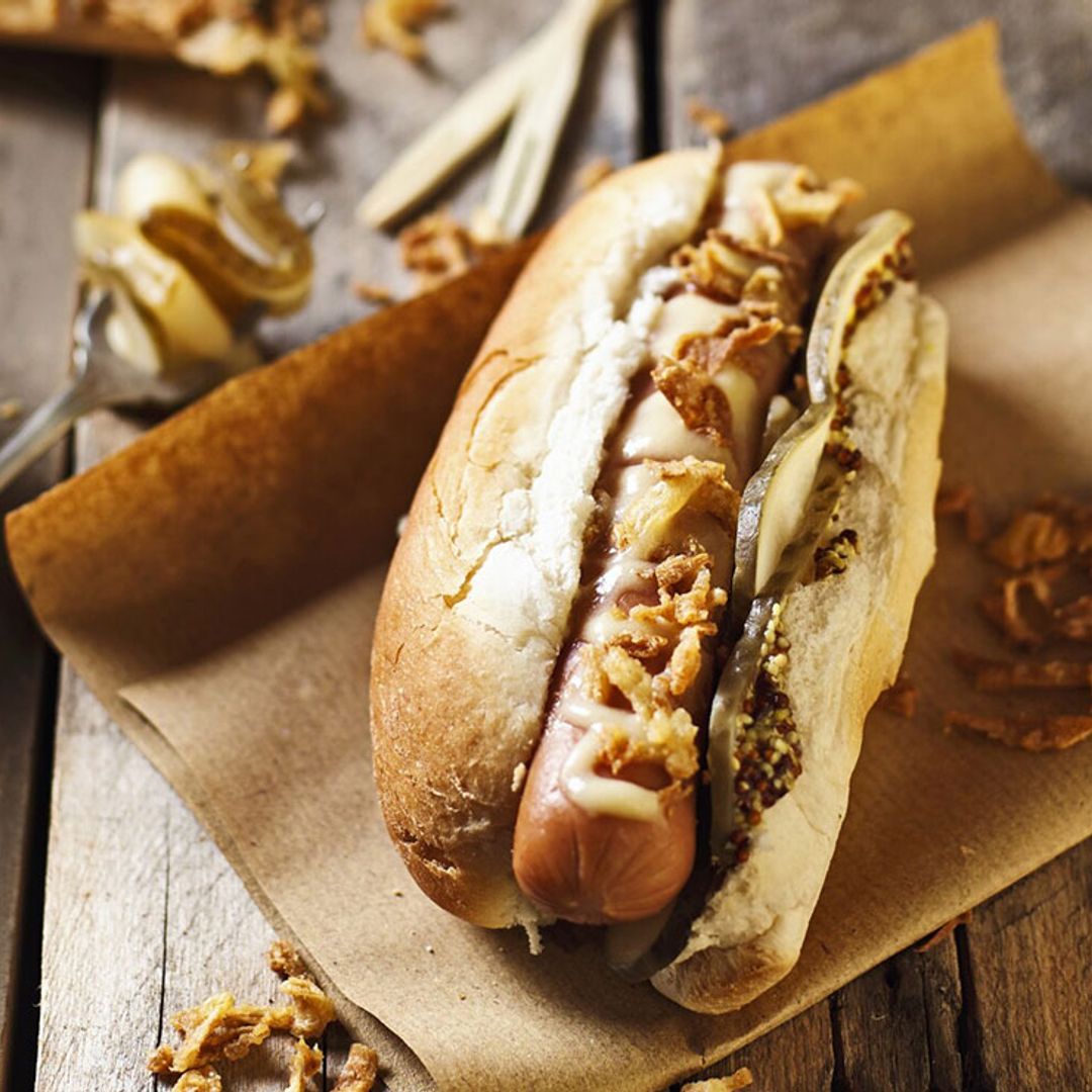 Perrito caliente con queso cheddar y cebolla crujiente
