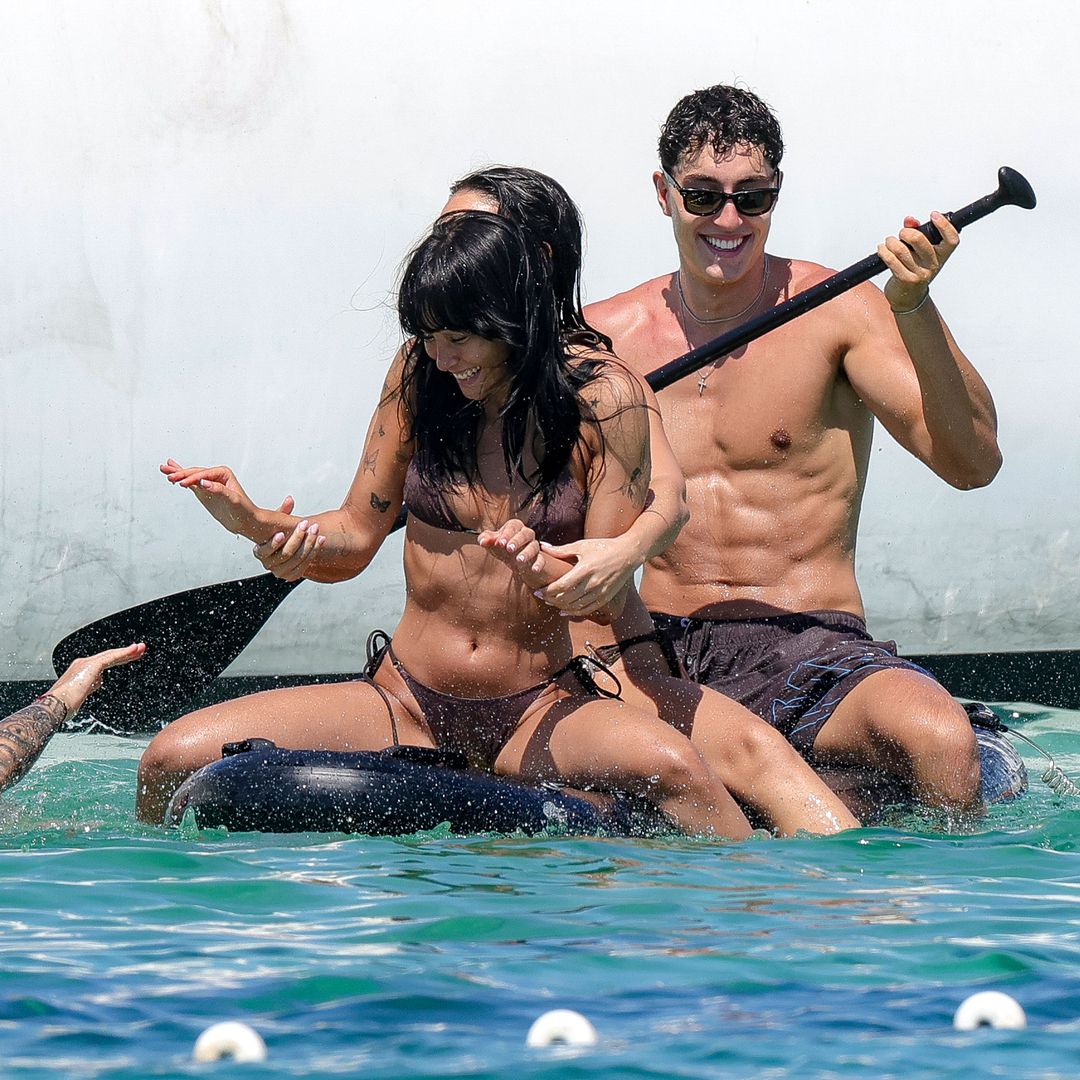 Aitana y Plex en una tabla de paddle surf con amigos