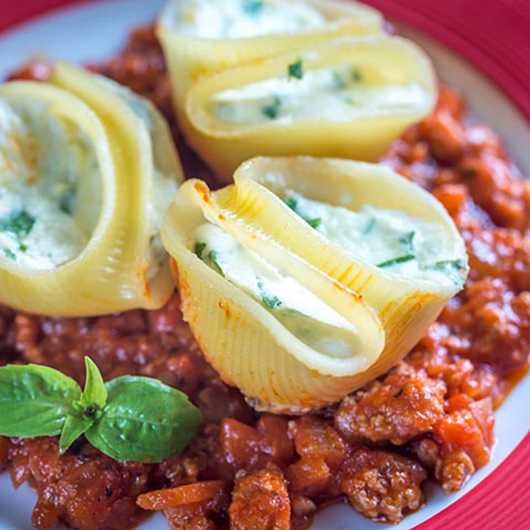 Caracolas rellenas de ricotta sobre cama de boloñesa
