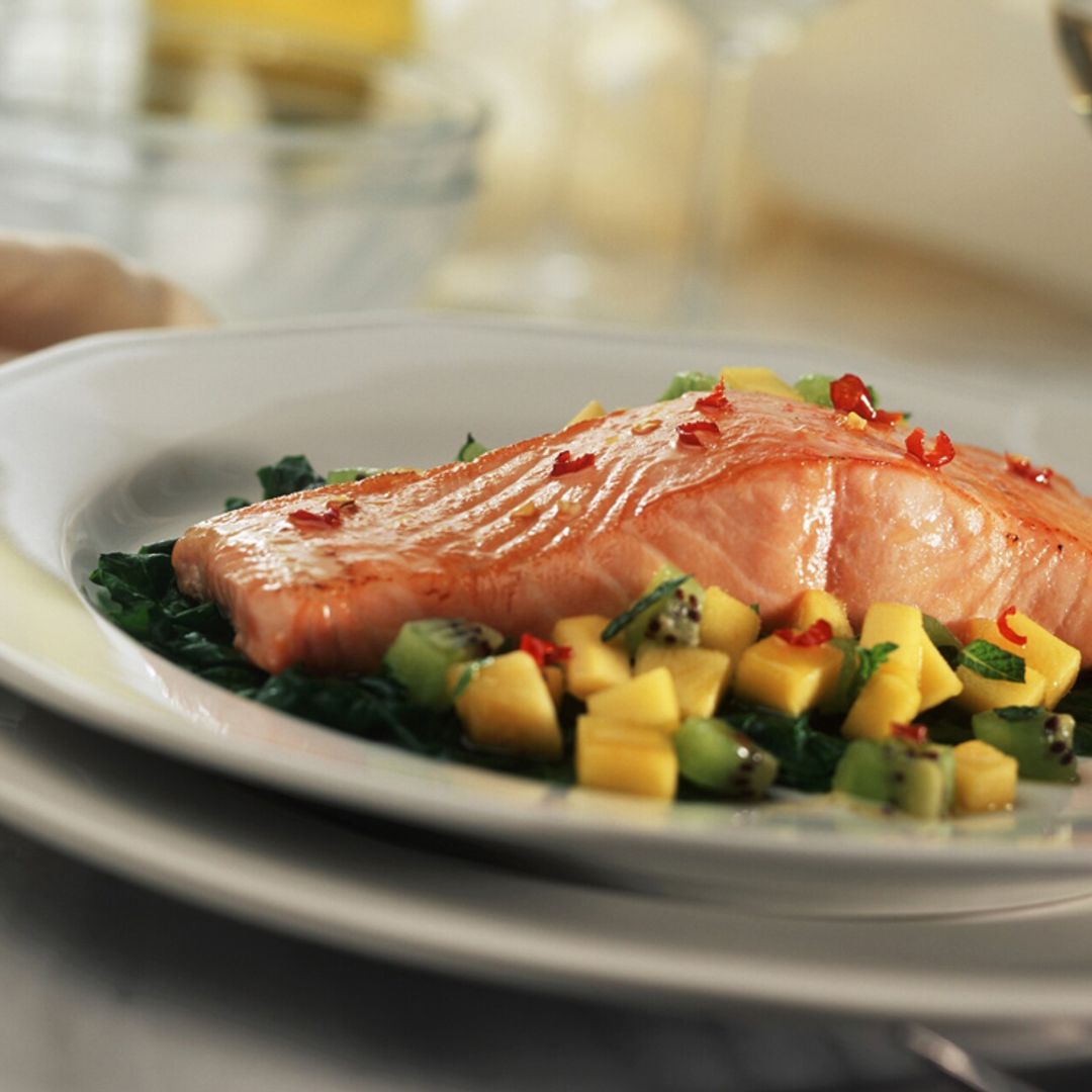 Salmón al horno sobre ensalada de hojas frescas y frutas con chile