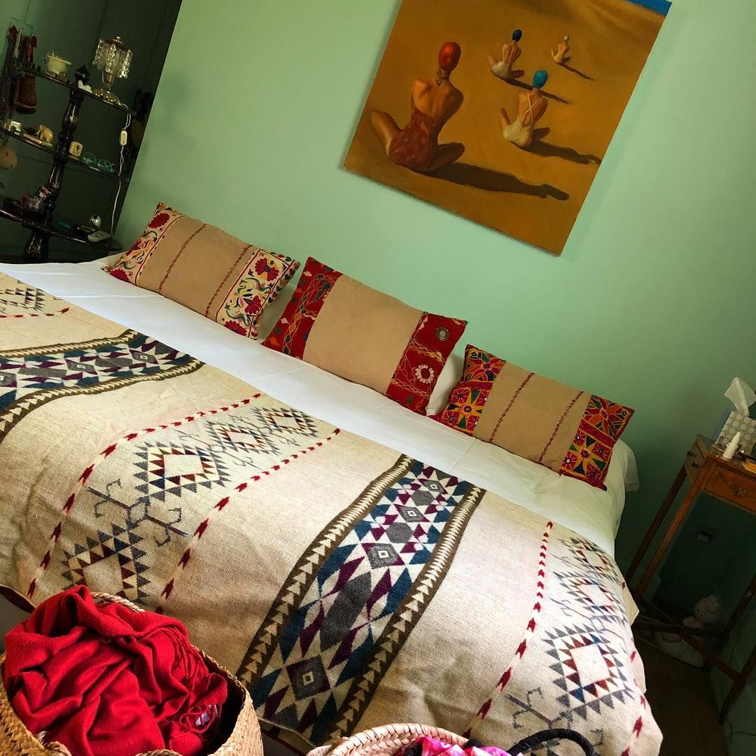 Una de las habitaciones de Eugenia Martínez de Irujo, pintada en verde menta y con el contraste del mostaza en el lienzo y en los cojines étnicos