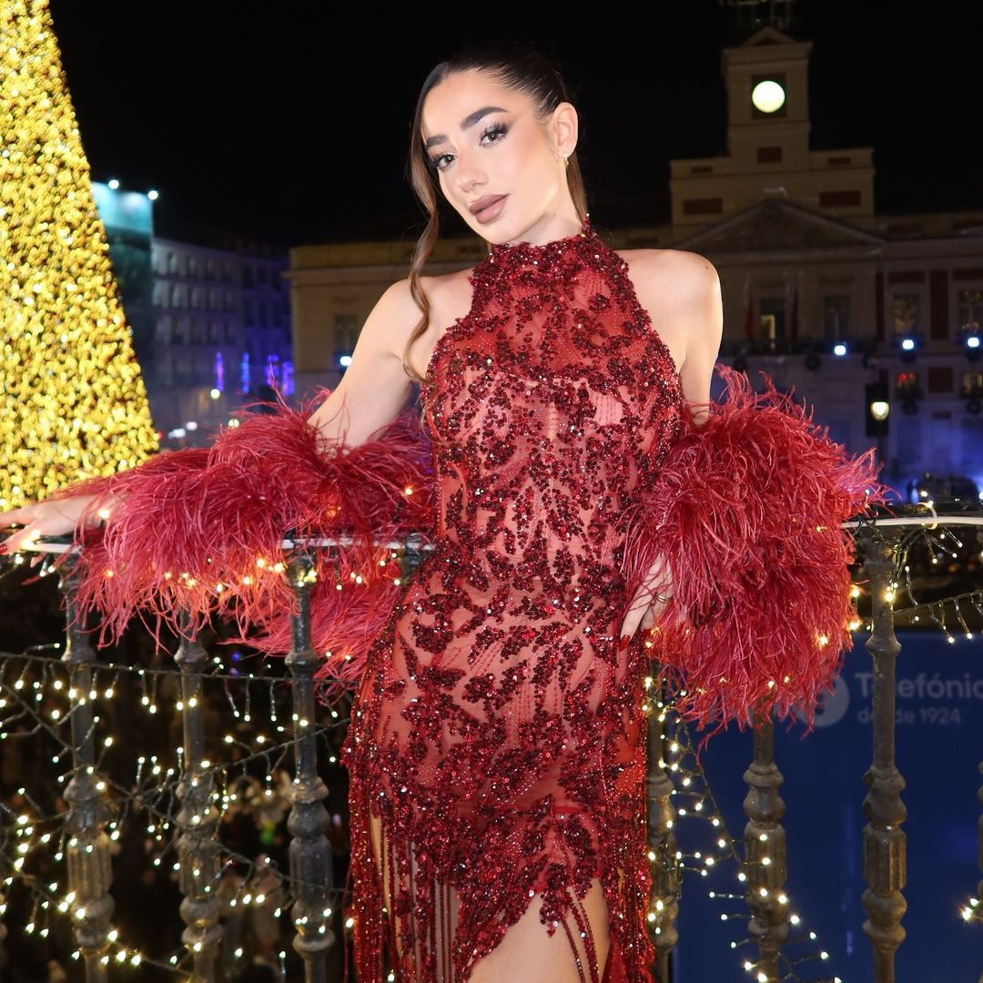 Lola Lolita deslumbra en las preuvas con un minivestido burdeos y una boa de plumas