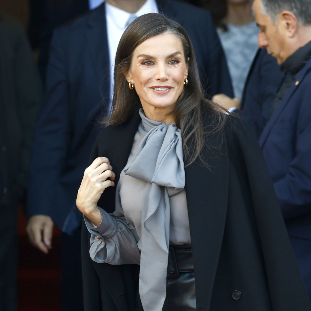 El juego de contrastes de la reina Letizia en el Teatro Real de Madrid: blusa semitransparente con lazada y roquera falda de cuero