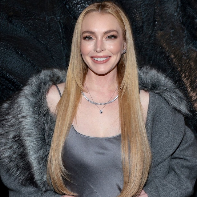 Lindsay Lohan con abrigo de pelo gris, vestido a juego y pelo suelto en el desfile Michael Kors 2024