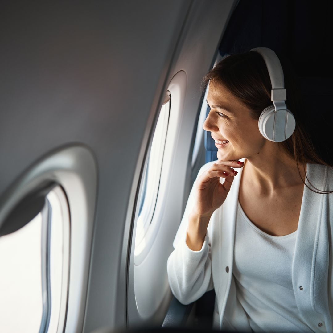 Pasajera en el avión con auriculares