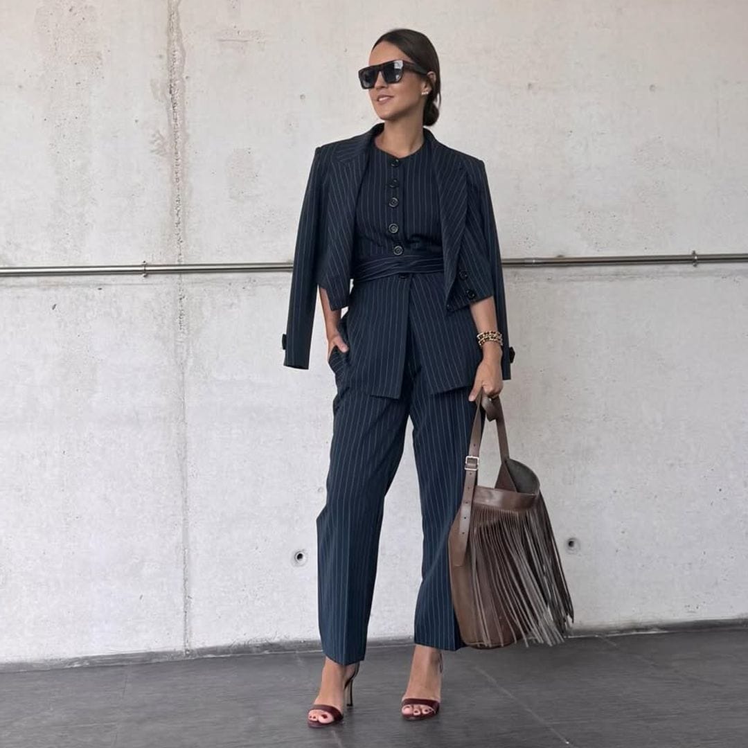Virginia Pozo en traje azul, gafas de sol y bolso de flecos