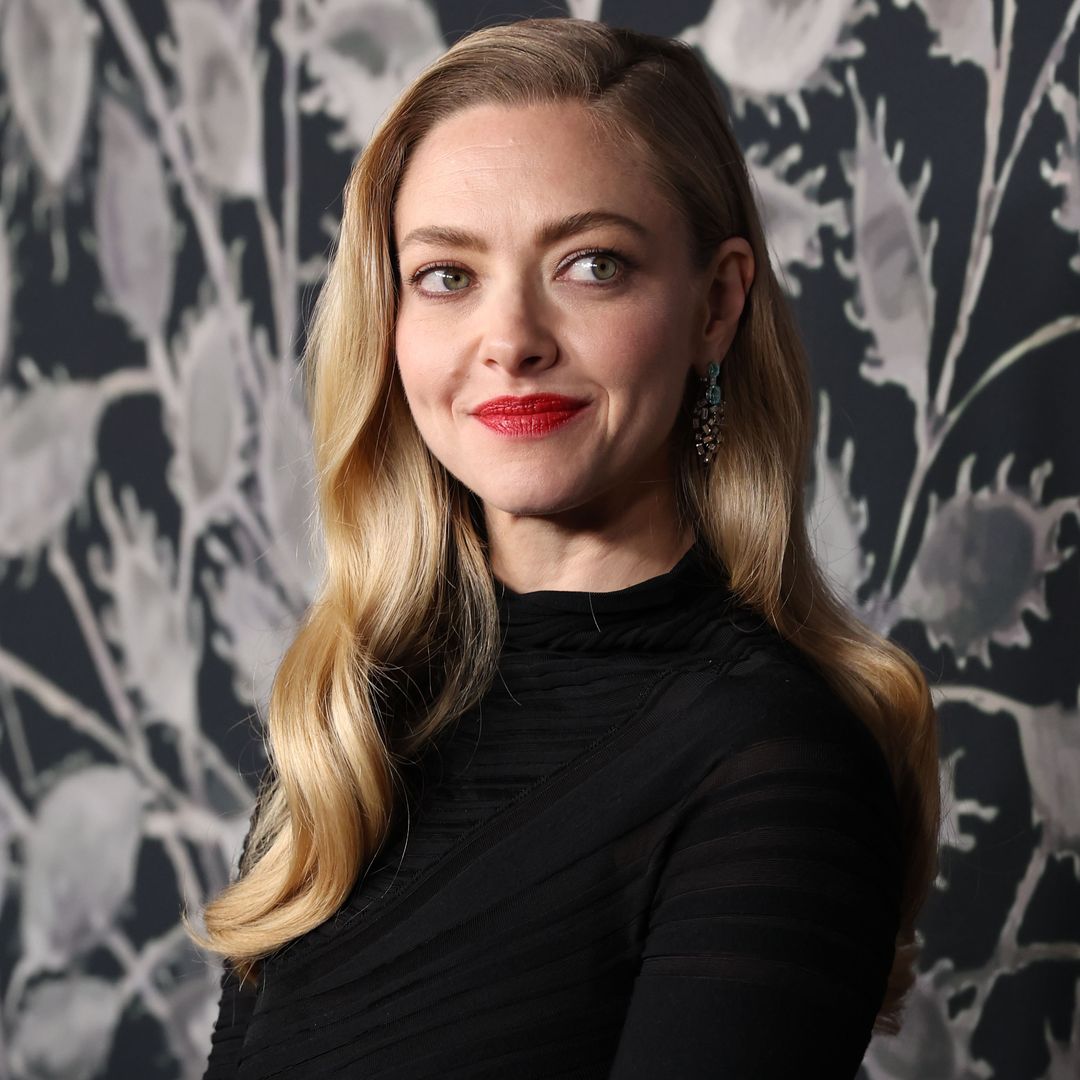 Amanda Seyfried con vestido negro, labios rojos y melena ondulada en el estreno de El testamento de Ann Lee