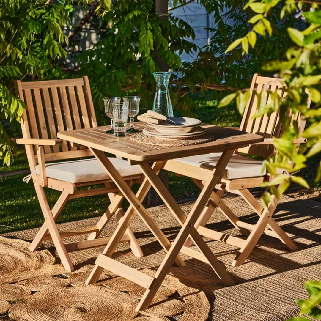 Muebles de madera para terraza, una mesa con sus sillas, rodeado todo de plantas.