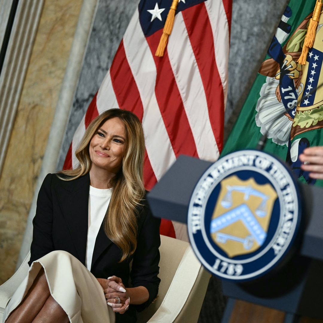 Melania Trump con vestido blanco satinado y americana negra