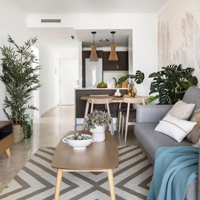 Salón abierto a la cocina con sofá gris y muebles de madera.