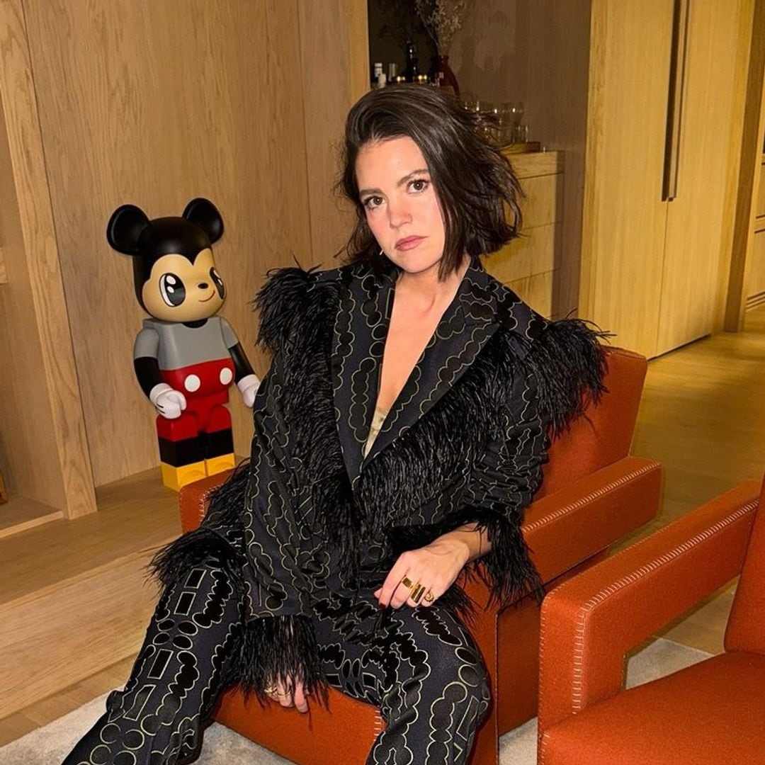 Isabelle Junot con traje negro de brillos y plumas