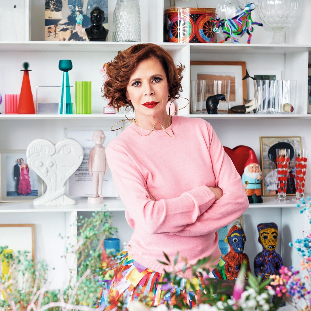 Ágatha posa junto a una de sus múltiples estanterías, decorada con cerámicas, cristalerías, esculturas tribales de Camerún… y una foto suya con Luis Miguel Rodríguez, conocido como "el Chatarrero"