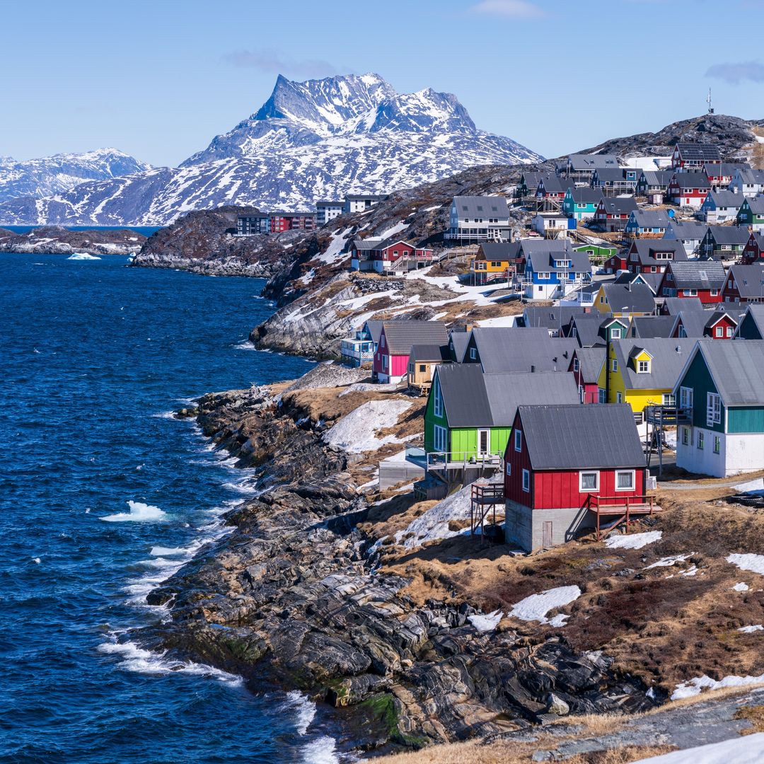 coloridas casas enclavadas a lo largo de la costa de Nuuk, Groenlandia, con la montaña Sermitsiaq al fondo