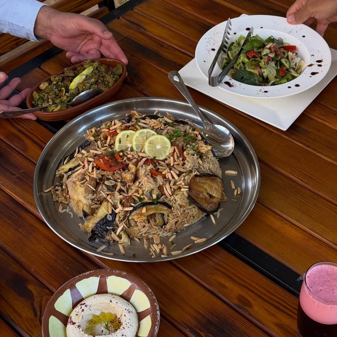 La makluba se cocina en capas y se voltea en la bandeja al servirlo, y fattoush es la clásica ensalada.