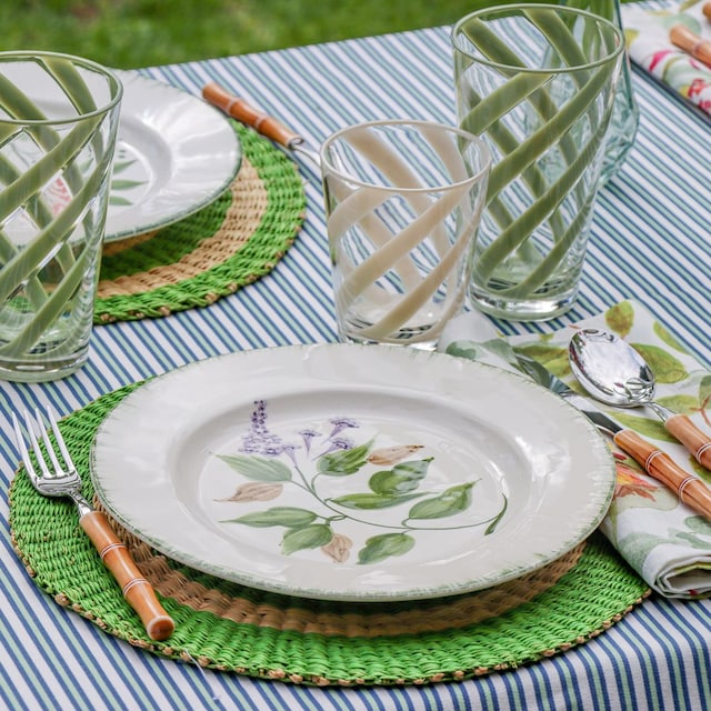 Mesa de verano con mantel a rayas y vajilla con motivos botánicos