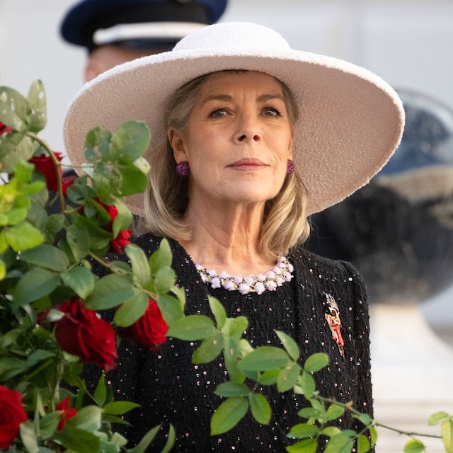 Plano medio de Carolina de Mónaco con traje negro de tweed y sombrero blanco