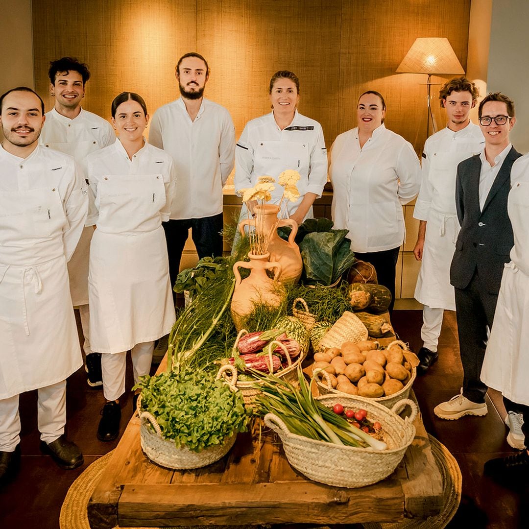 La chef posa con su equipo junto a la cosecha del día