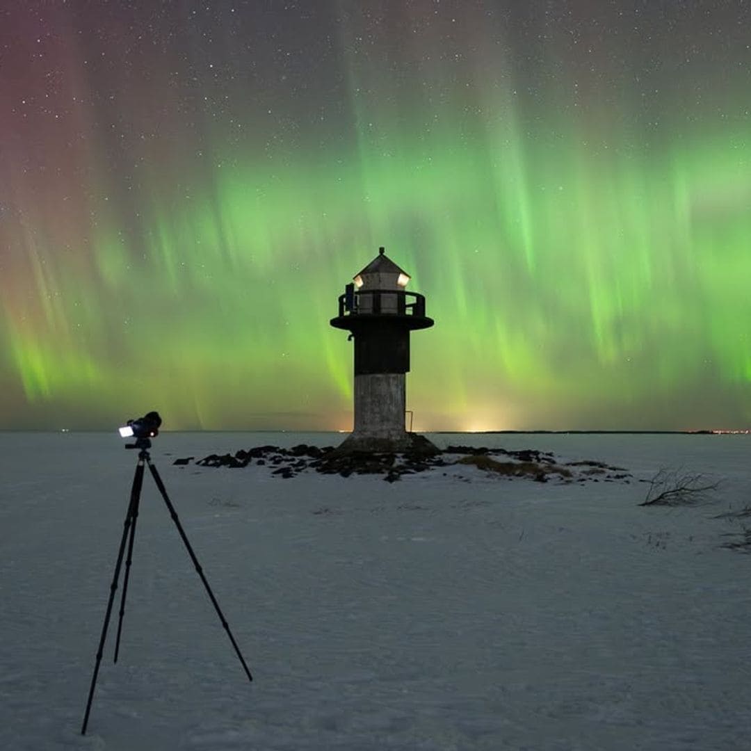 Faro bajo las auroras boreales de Oulu, finlandia