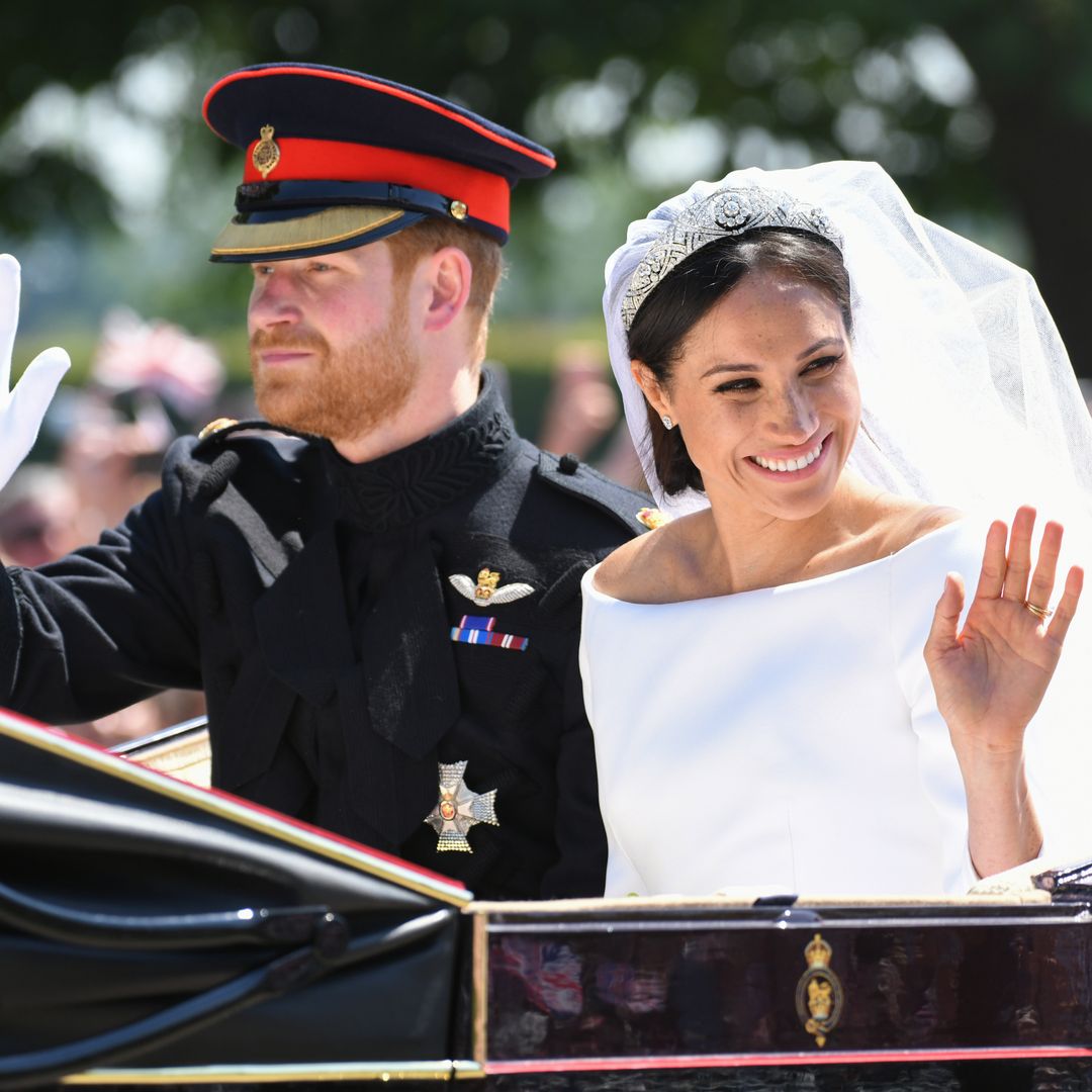 Plano medio de Harry y Meghan de Inglaterra saludando desde su carruaje tras la boda