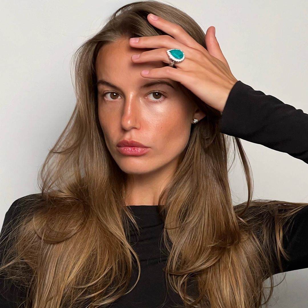 Primer plano de la modelo Alyona Lozovaya con pelo suelto, jersey negro y anillo turquesa en el dedo