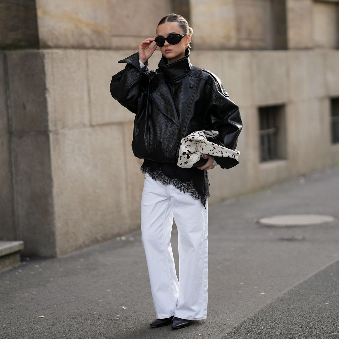 Look con cazadora oversize de cuero y vaqueros blancos