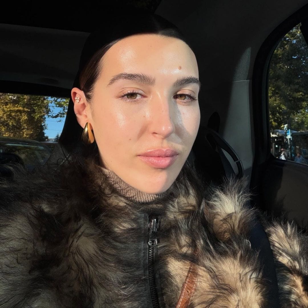 Alba Díaz en el coche con abrigo de pelo y piel luminosa sin maquillar