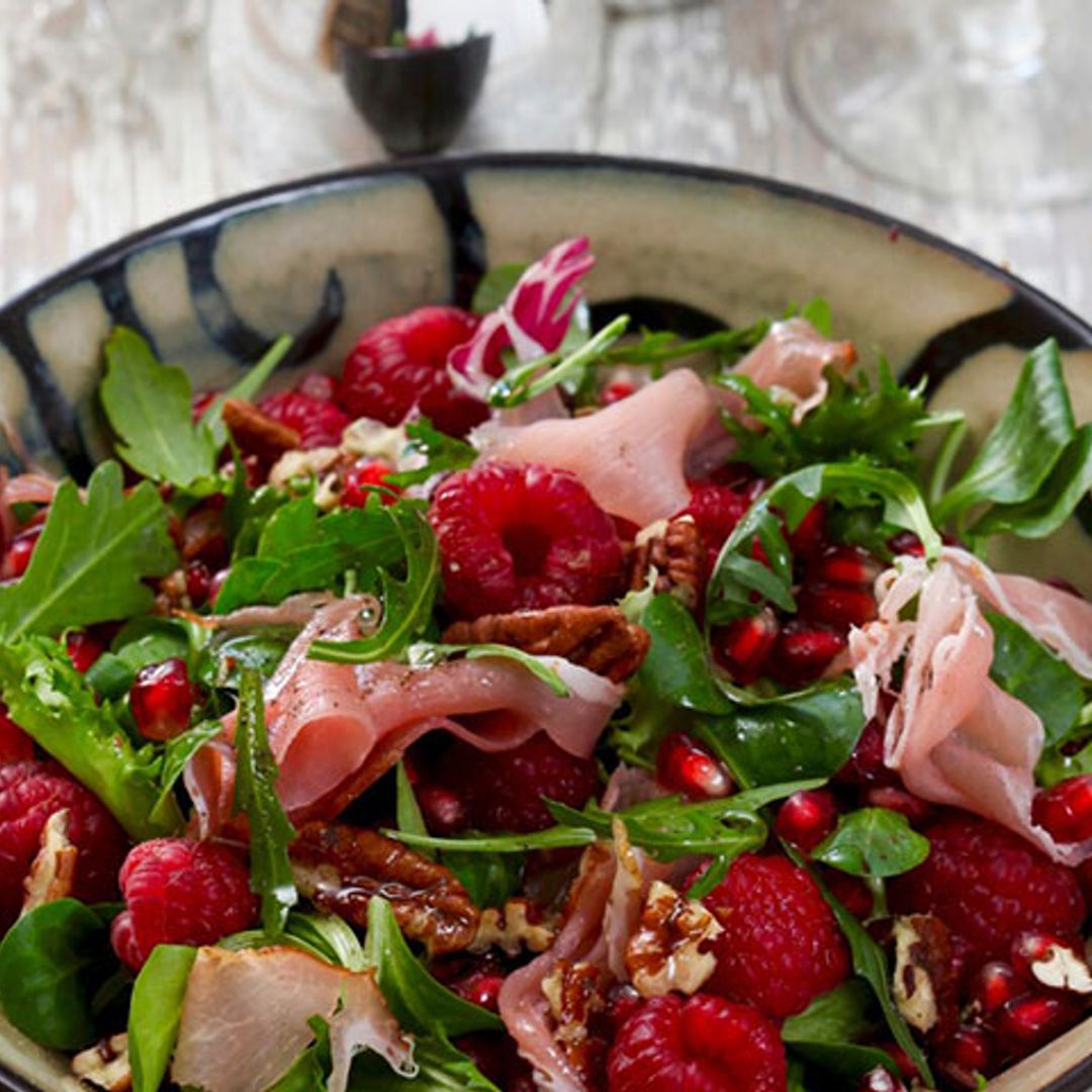 Ensalada de rúcula, frambuesas, granada, nueces pecanas y jamón