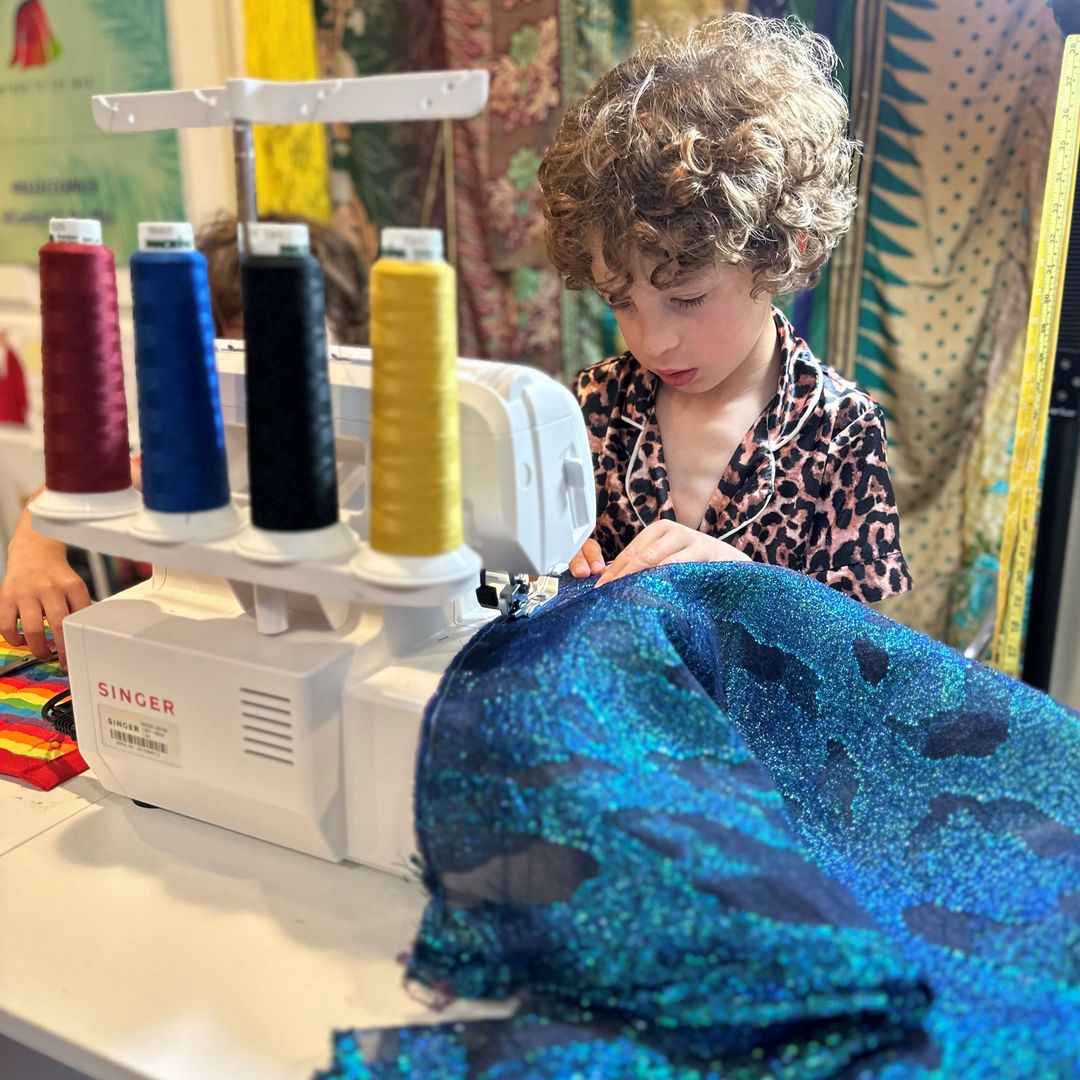 El joven diseñador, Max Alexander, enfocado y con las manos metidas en la mesa, durante uno de sus diseños