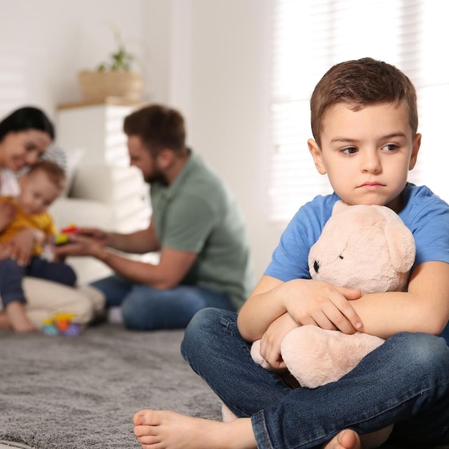 hermano mayor triste mientras sus padres juegan con hermano peque o