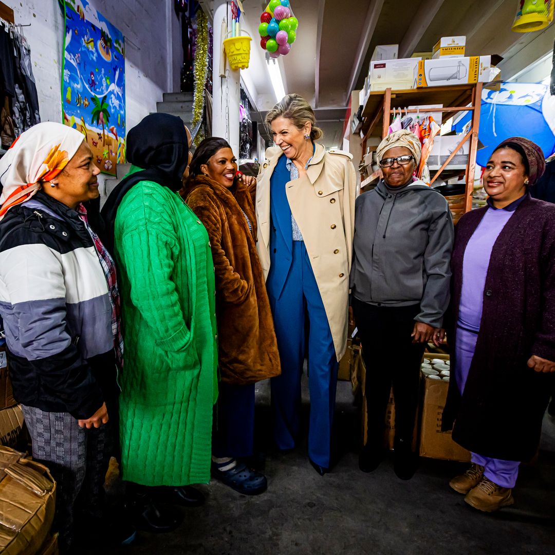 La reina Máxima luce un traje azul y gabardina en su viaje a Sudáfrica
