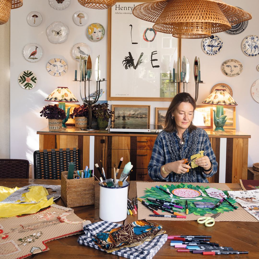  Krystyna (aquí, haciendo uno de sus "collages", su otra pasión) siempre apuesta por la artesanía de su país, y le fascinan las mariposas como elemento decorativo (unos insectos que también forman parte del universo creativo de su hermana)