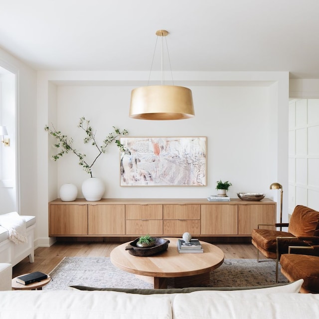 Salón con lámpara en tono dorado, y aparador bajo de madera, sofás y asientos dispuestos todos en U