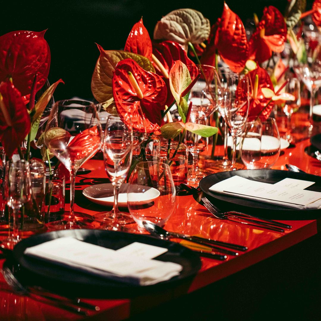 Las mesas de la cena se adornaron con anturios en color rojo.