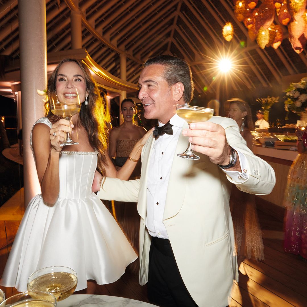 Hombre y mujer elegantes brindando con copas en una fiesta nocturna.