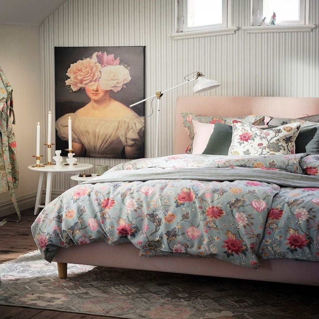 Dormitorio en tonos pastel con funda nórdica de estampado floral y cuadro al fondo de IKEA