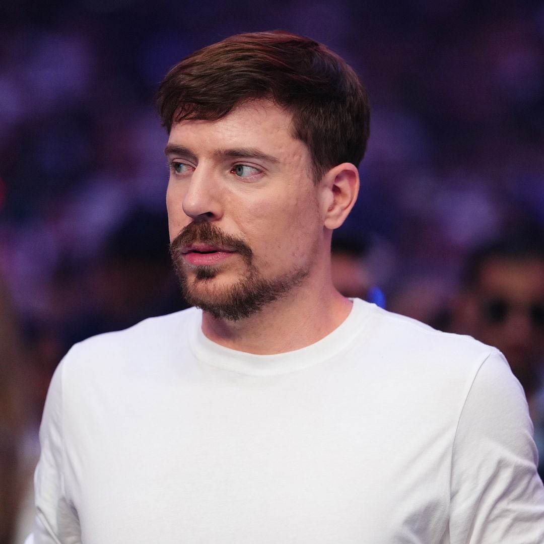 MrBeast, con barba y bigote, viste una camiseta blanca en un evento.