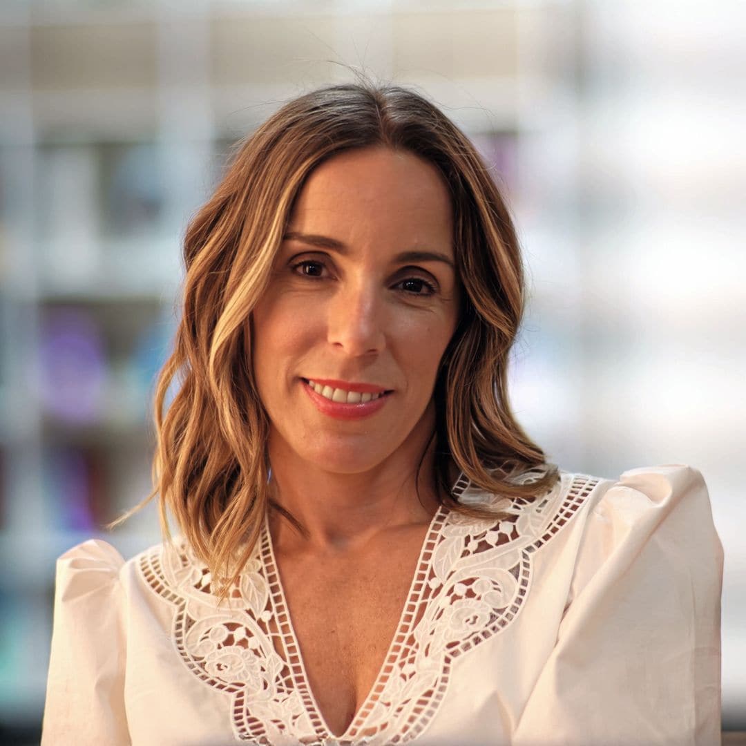 Ana Aznar con cabello rubio en blusa blanca sonriendo