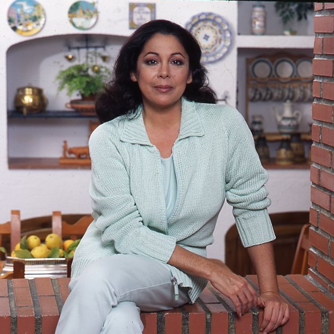 Isabel posa sentada en el arco de ladrillo que separa la cocina del comedor
