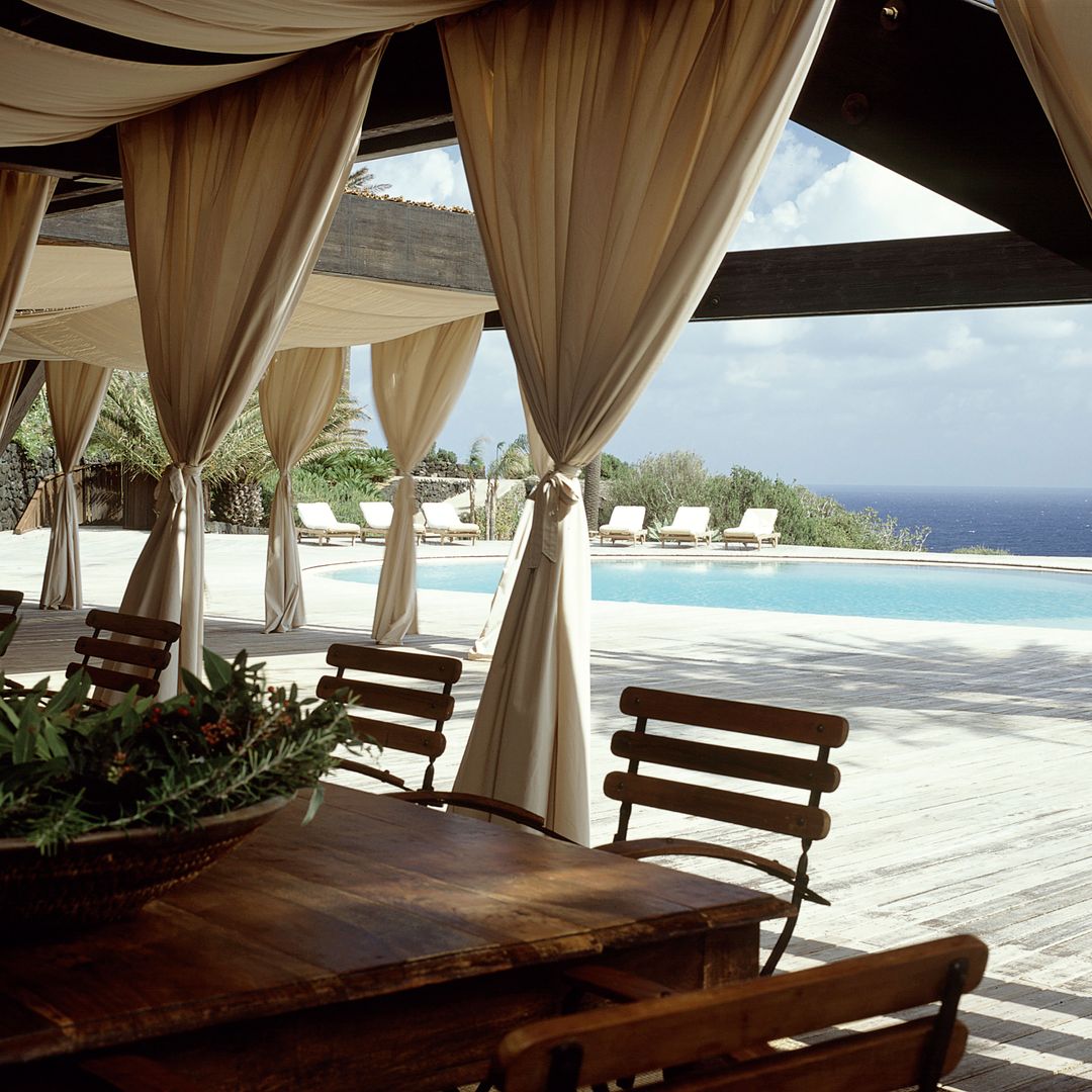 La zona de la piscina, junto al comedor exterior, con vistas al mar.