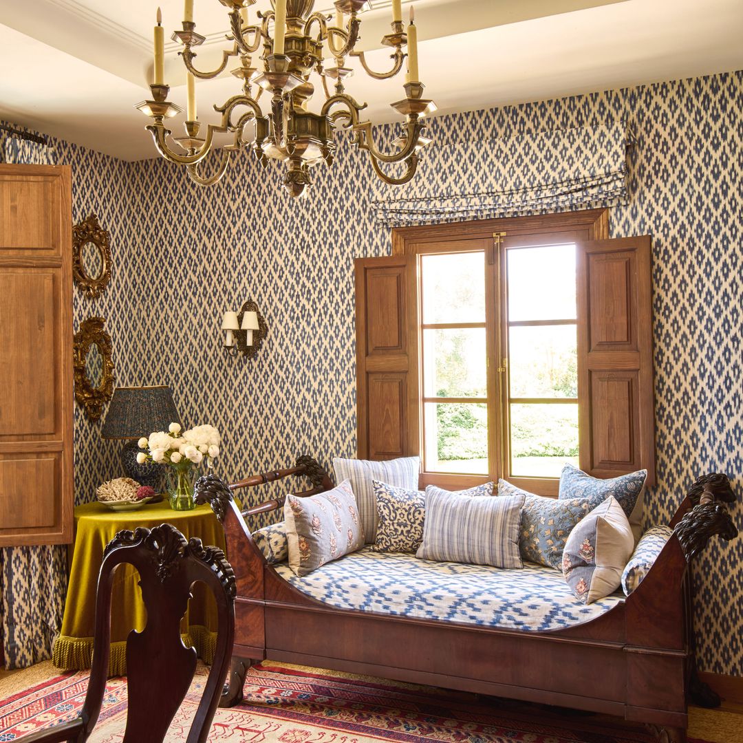 Un diván de madera tapizado con tela artesanal tejida a mano de Artesanía Textil Bujosa en el interior de la casa de James Costos y Michael Smith