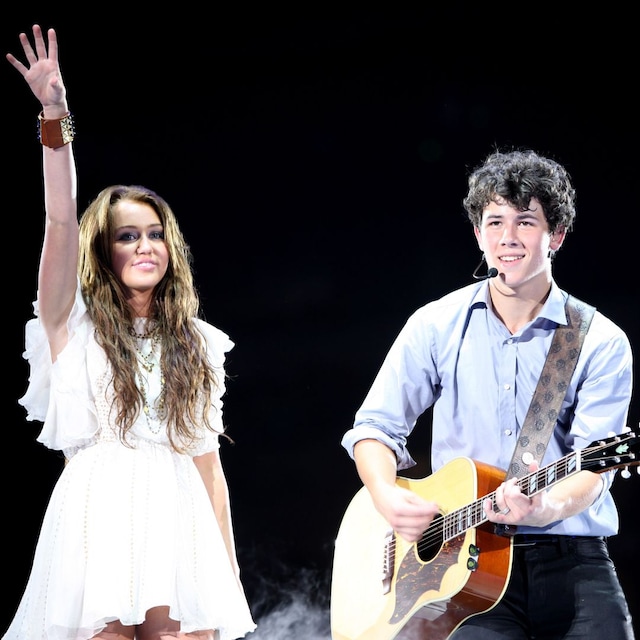 Los músicos Miley Cyrus y Nick Jonas de Jonas Brothers actúan en el New Cowboys Stadium el 20 de junio de 2009 en Dallas, Texas.